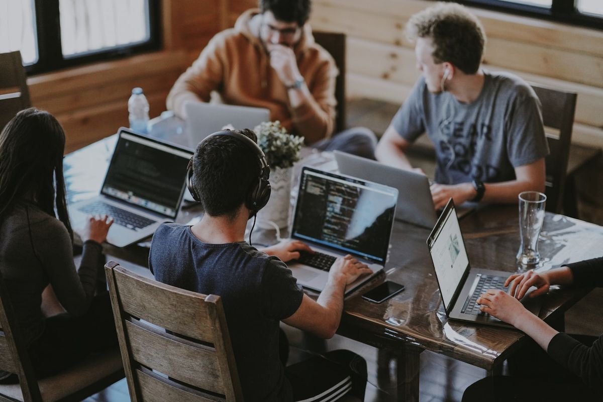 People collaborating around a laptop in an office